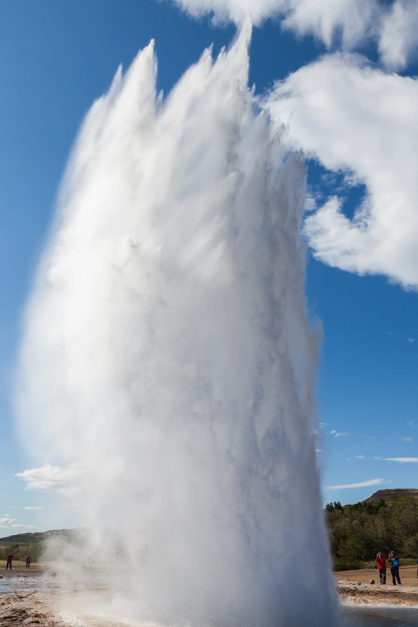 Strokkur erupts against a blue sky in the Geysir geothermal area