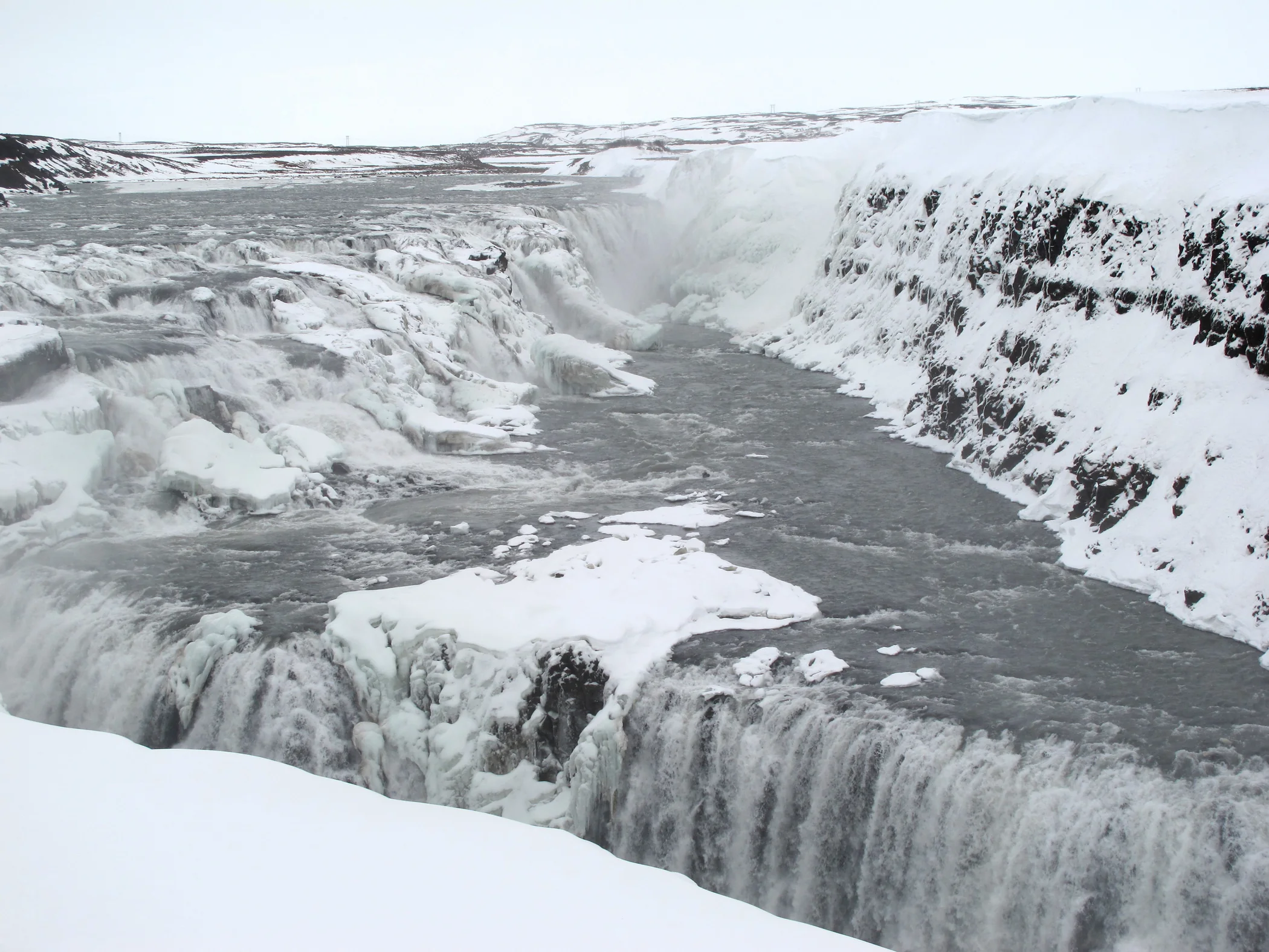 Winter snow borders the two falls and canyon at Gullfoss